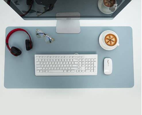 a computer desk with a keyboard, mouse and headphones